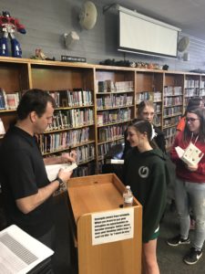 Author Brendan Reichs signs prize giveaway books for EverGreen Jr. High students