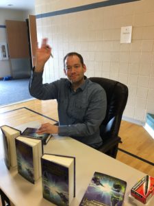 Author Brandon Mull signing books for students