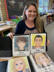 Teacher Stephanie Gonzalez poses with avatars created by her fifth grade students. QR codes on the avatars take parents to a digital portfolio showcasing the student's learning.