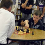 Photo of Superintendent Bates playing chess with a student