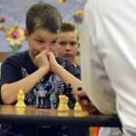 Photo of a student playing chess with Superintendent Bates