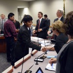 Photo of student and father shaking hands with board of education