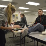 Photo of CTE student applying bandage to student volunteer