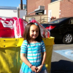 Photo of Whittier Elementary student in front of donated items