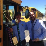 Photo of bus driver receiving trophy from assistant principal