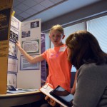 Photo of student explaining science fair project to judge