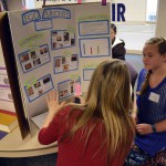 Photo of student explaining science fair project to judge
