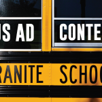 Photo of school bus window with added text 'Bus Ad Contest'