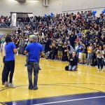 Photo of family speaking in front of student body