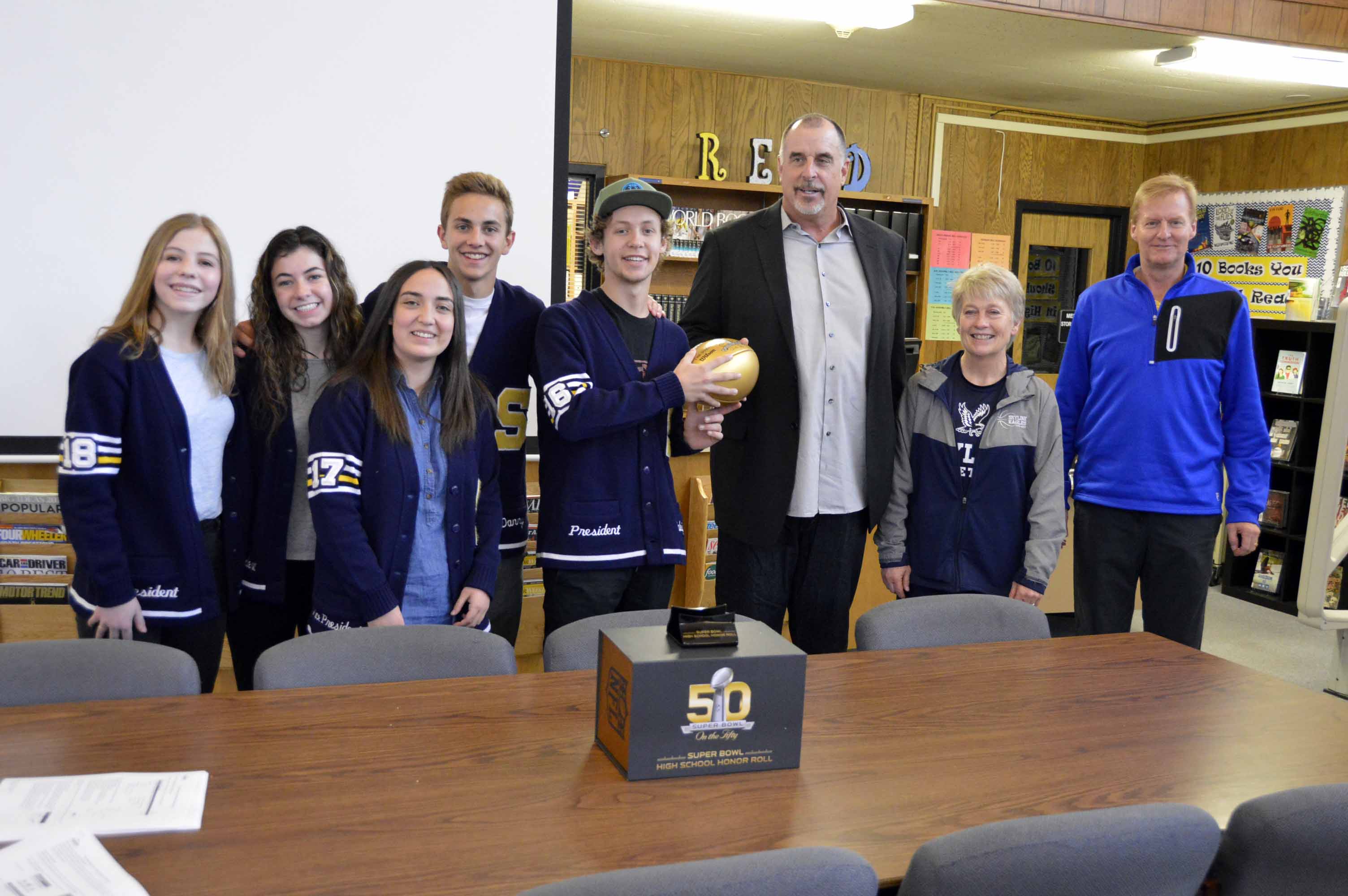 Former NFL player presents commemorative gold football to alma mater