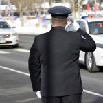 Photo of officer saluting police cars