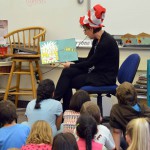 Photo of volunteer reading book to Moss Elementary students