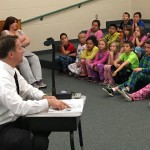 Photo of superintendent reading book to Wright Elementary students