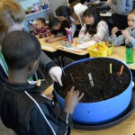 Photo of GTI student helping Wilson student plant seeds