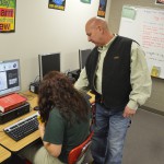 Photo of teacher instructing student on computer