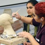 Student working on bust sculpture
