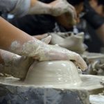 Student hands on wheel thrown ceramics