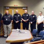 Police officers stand to be recognized during board meeting