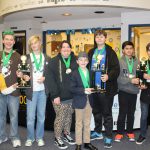 Junior high students stand with trophies and medals