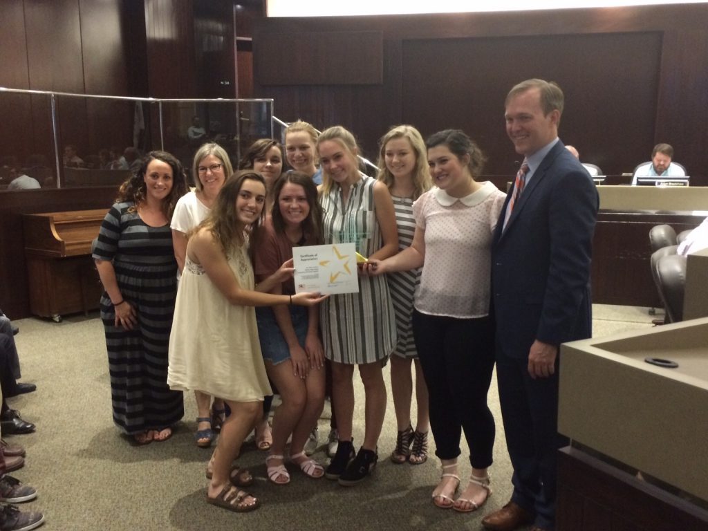 Skyline High students hold up award with Salt Lake County mayor