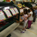 Students fill their lunch trays at a food cart