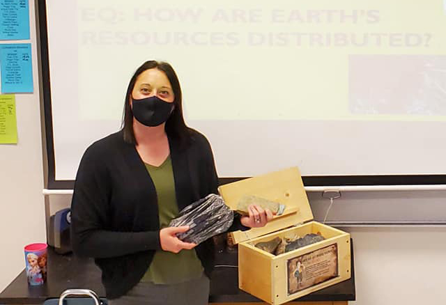 Science teacher holds rock samples