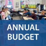 Classroom with students giving presentation. Text: Annual Budget