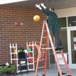 Picture of teacher dropping pumpkin from ladder
